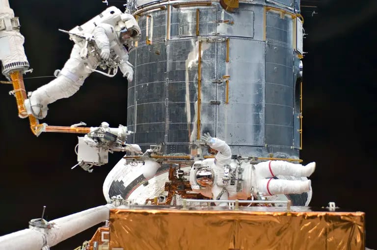 Los astronautas del transbordador espacial estadounidense Atlantis reparan y mejoran el telescopio espacial Hubble en 2009.Fuente: NASA.dfd