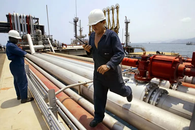 Empleados de Petróleos de Venezuela SA (PDVSA), la compañía petrolera estatal de Venezuela, inspeccionan oleoductos durante una gira de prensa del complejo de refinería El Palito, a unas 150 millas al oeste de Caracas, el viernes 28 de marzo de 2003. dfd