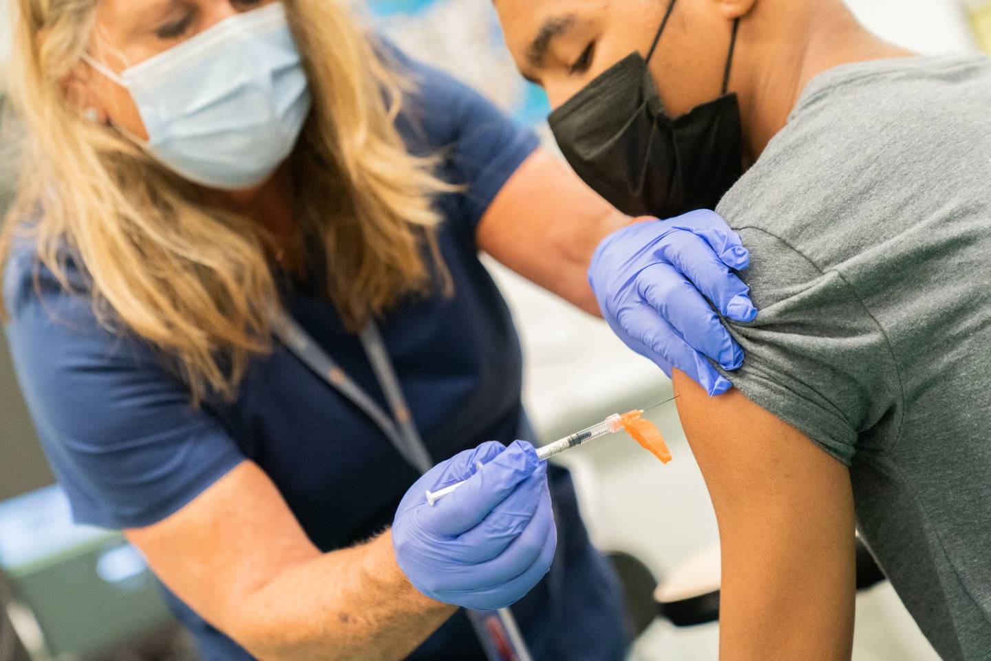 Un trabajador sanitario administra una dosis de la vacuna Covid-19 de Pfizer-BioNTech a un estudiante en un instituto del distrito neoyorquino de Staten Island.