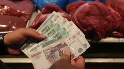 Un cliente cuenta billetes de rublo mientras compra productos cárnicos de granja a un comerciante en el mercado de alimentos Dorogomilovsky en Moscú, Rusia, el viernes 10 de agosto de 2018.