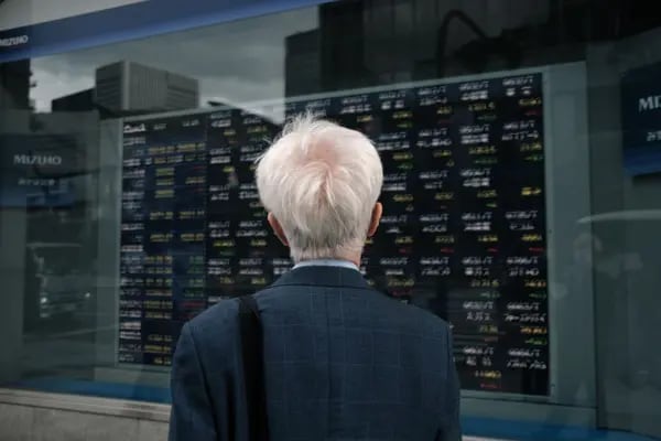 Un hombre mira una pizarra electrónica fuera de una firma de valores en Tokio, Japón,