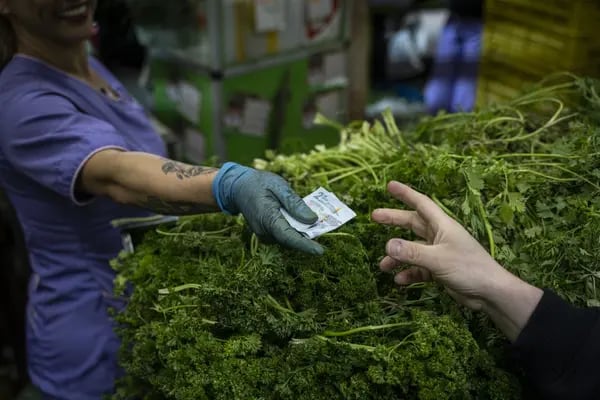 Un comprador paga por productos en un mercado de alimentos en Bogotá, Colombia, el jueves 30 de marzo de 2023.