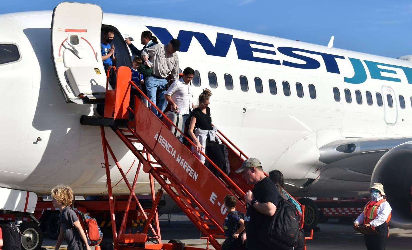 Turistas llegan al Aeropuerto Internacional Juan Manuel Gálvez, en Roatán, Honduras, procedentes de Toronto, Canadá en un vuelo de WestJet.
