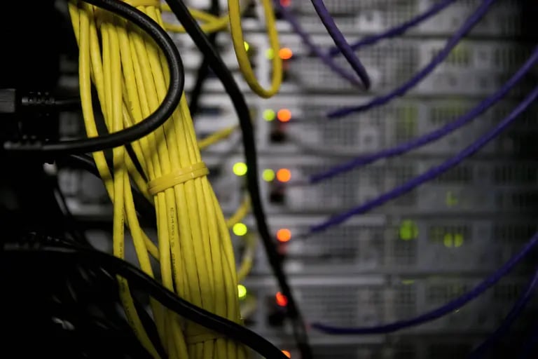 Cables de red cuelgan detrás de los servidores en una sala de ordenadores.dfd