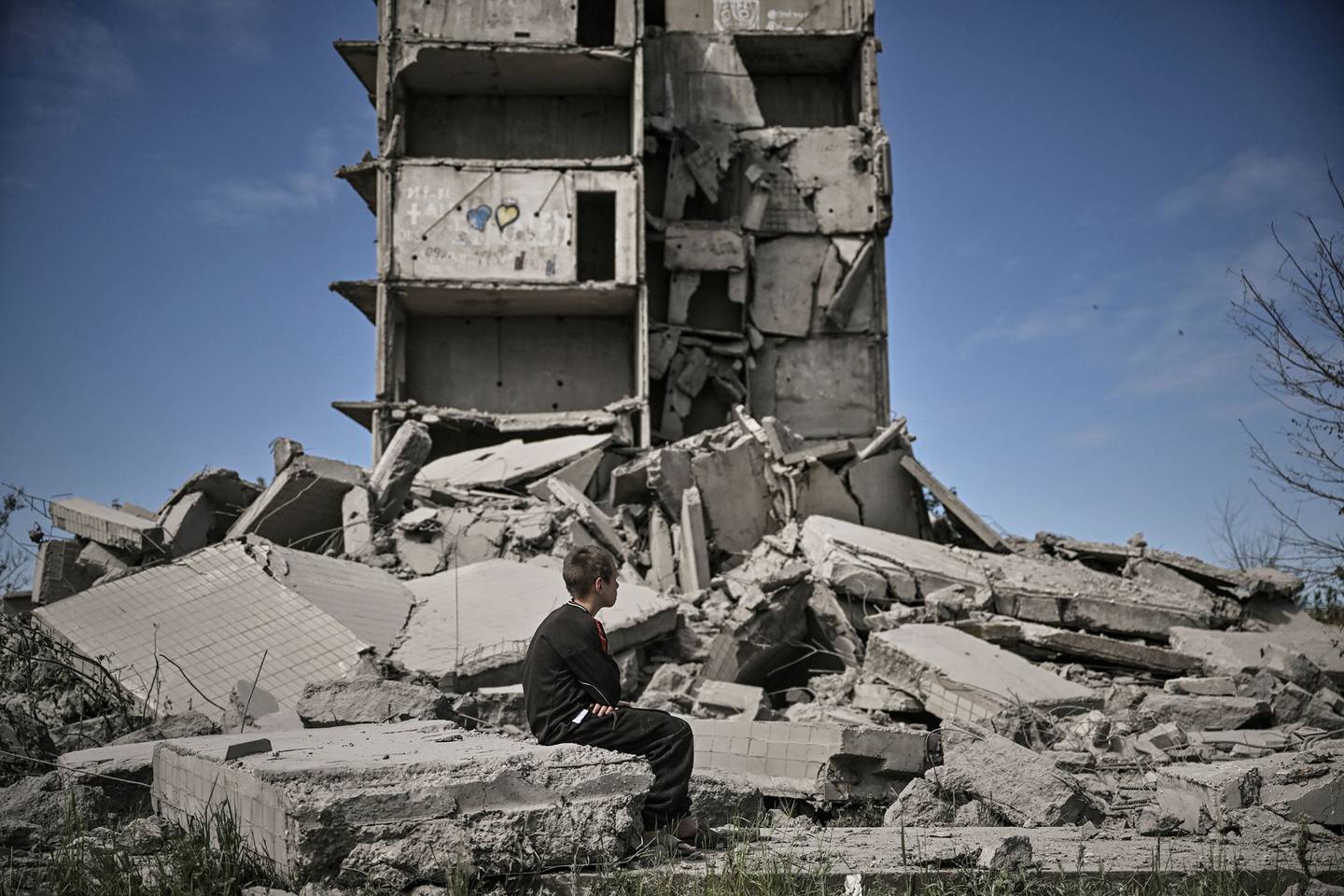 Un niño sentado frente a un edificio destruido tras un ataque en Kramatorsk, en la región oriental de Ucrania de Dombás, el 25 de mayo.