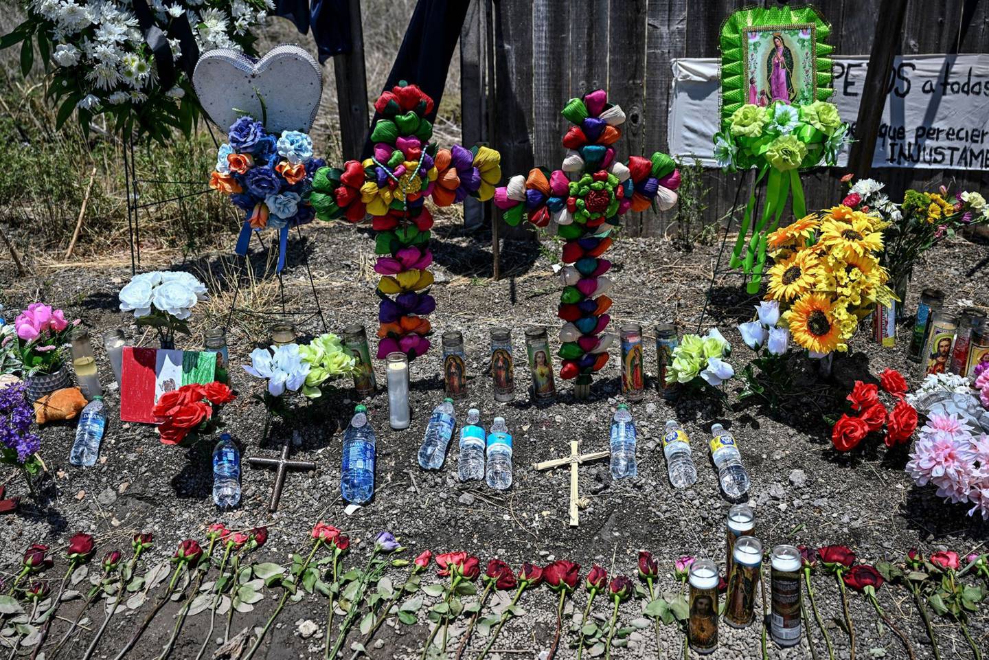 Botellas de agua se guardan en un monumento improvisado en el lugar donde se descubrió un tractor-remolque con migrantes dentro, en las afueras de San Antonio, Texas, el 29 de junio de 2022.  Fotógrafo: Chandan Khanna/AFP/Getty Images