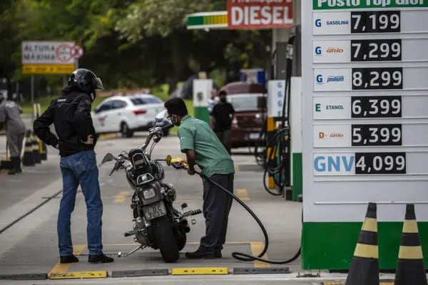 A worker refuels a motorcycle at a Petrobras gas station in Rio de Janeiro.