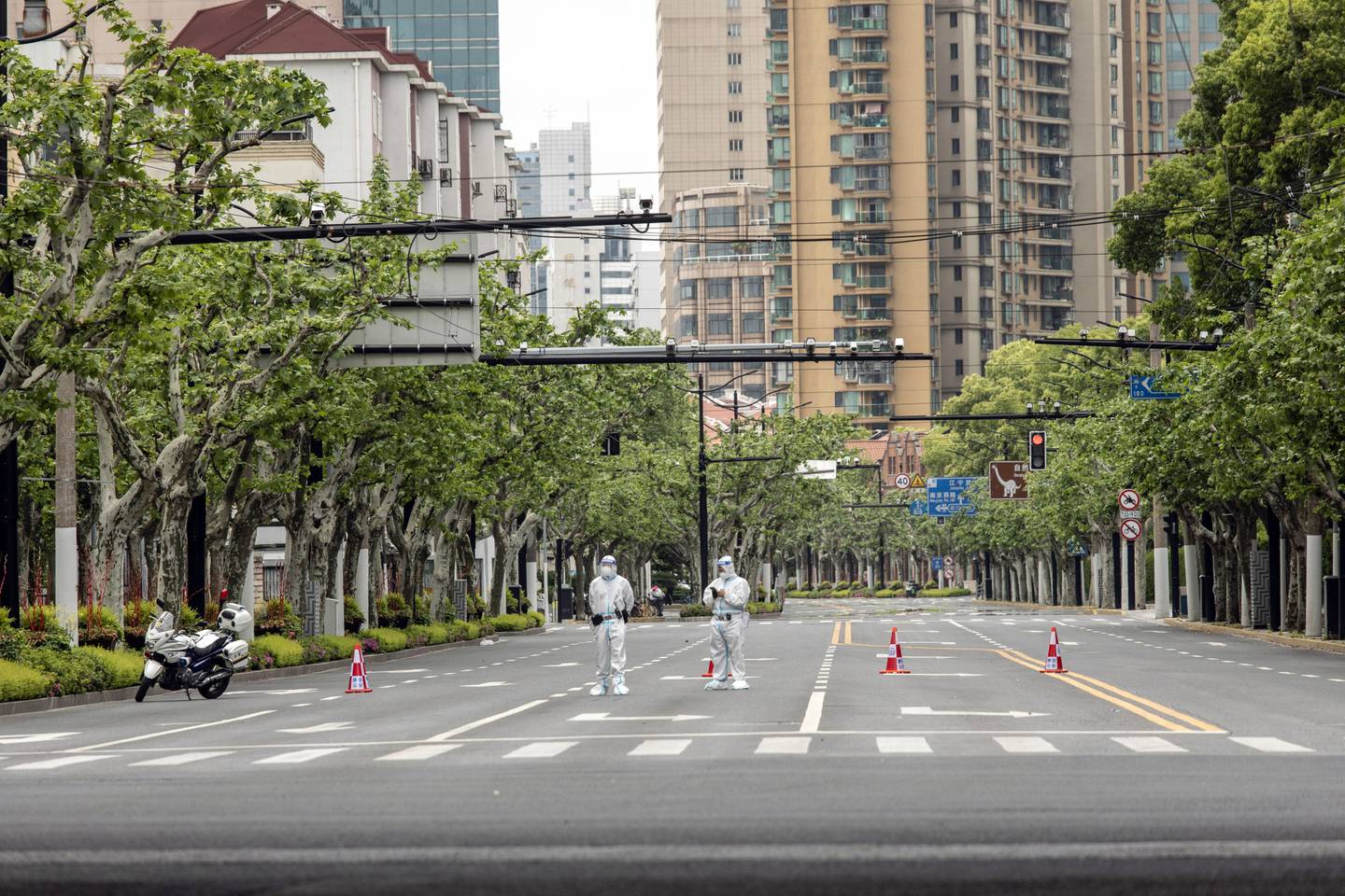 Oficiales de policía con equipo de protección personal hacen guardia en una intersección durante un cierre por covid-19 en Shanghái.Fuente: Bloomberg