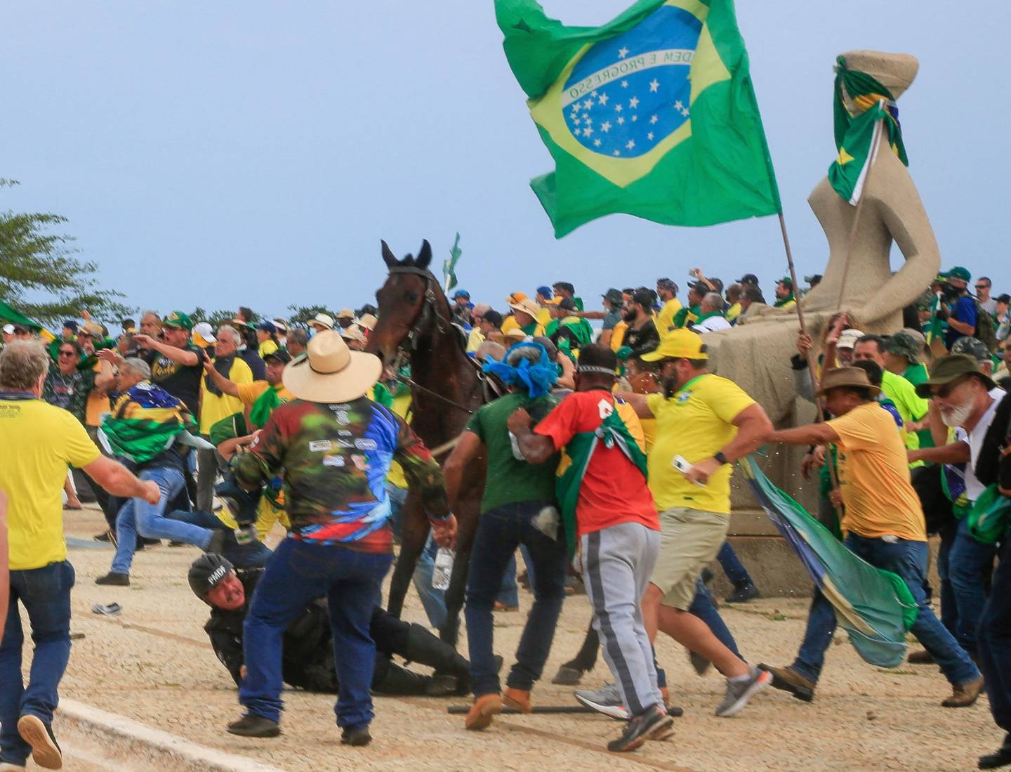 Un oficial de la Policía Militar cae de su caballo durante los enfrentamientos con partidarios del expresidente brasileño Jair Bolsonaro tras una invasión al Palacio Presidencial de Planalto en Brasilia el 8 de enero de 2023.