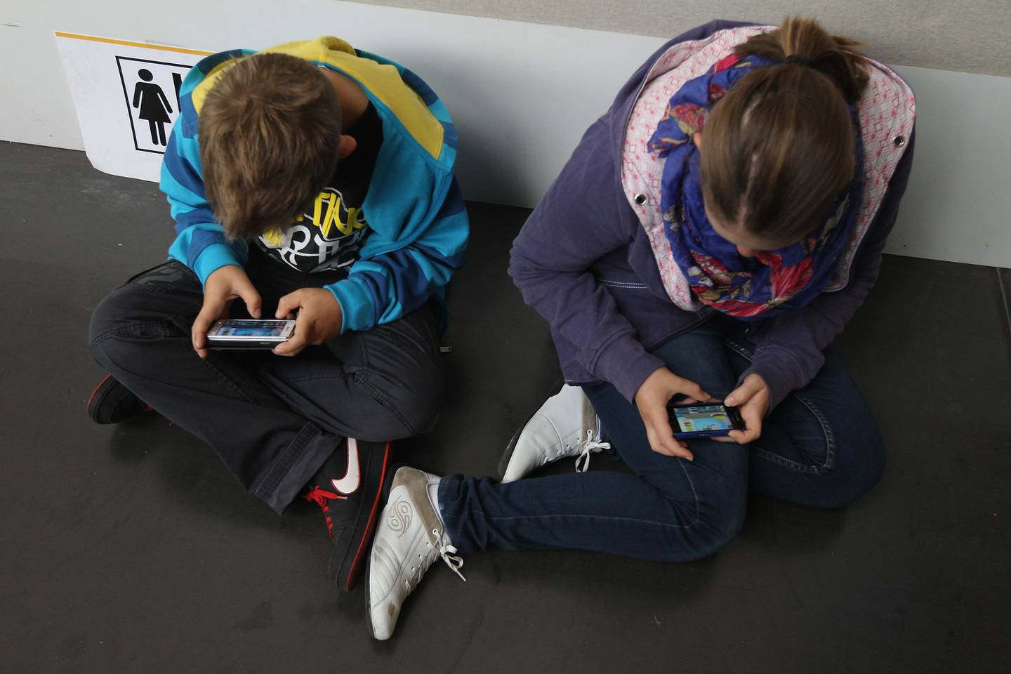 Unos niños juegan con sus smartphones mientras asisten a un acto público el 22 de septiembre de 2012 en Ruesselsheim, Alemania.