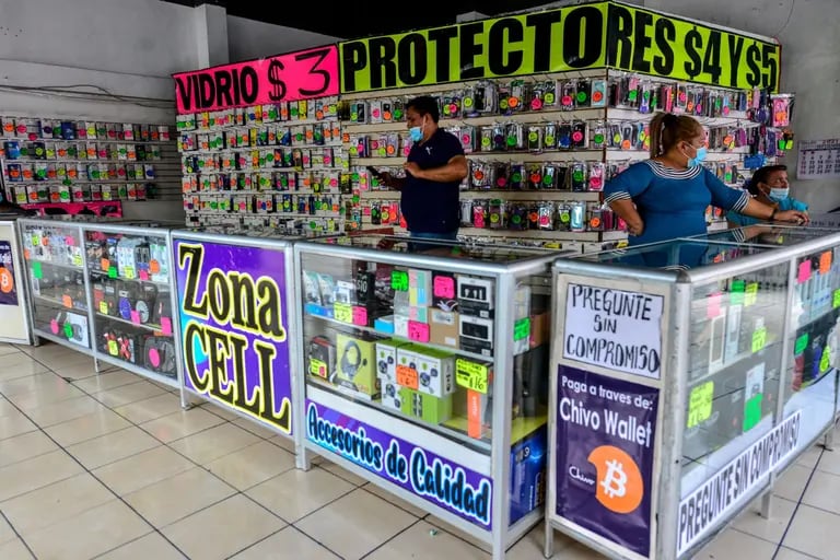 Trabajadores de una tienda de accesorios para teléfonos móviles que acepta bitcoin como método de pago en el Centro Histórico de San Salvador.dfd