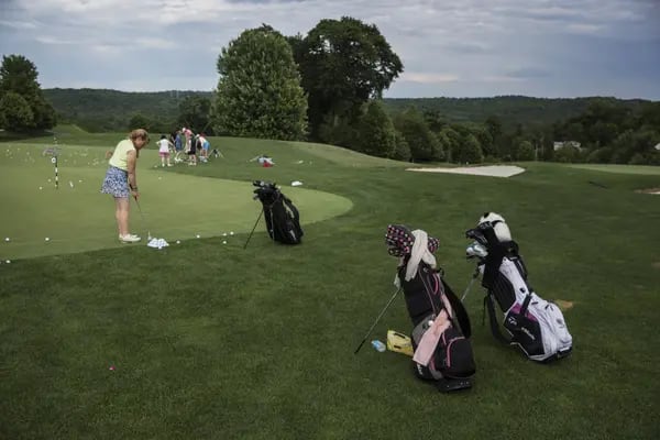 Golfers practice on the green before Donald Trump, presumptive Republican presidential nominee, not pictured, speaks during a primary night event at the Trump National Golf Club Westchester in Briarcliff Manor, New York, U.S., on Tuesday, June 7, 2016. Trump, who clinched the Republican nomination last month, is set face off against Hillary Clinton in the general election and the two are set to be formally nominated at their parties' conventions in July. Photographer: Victor Blue/Bloomberg