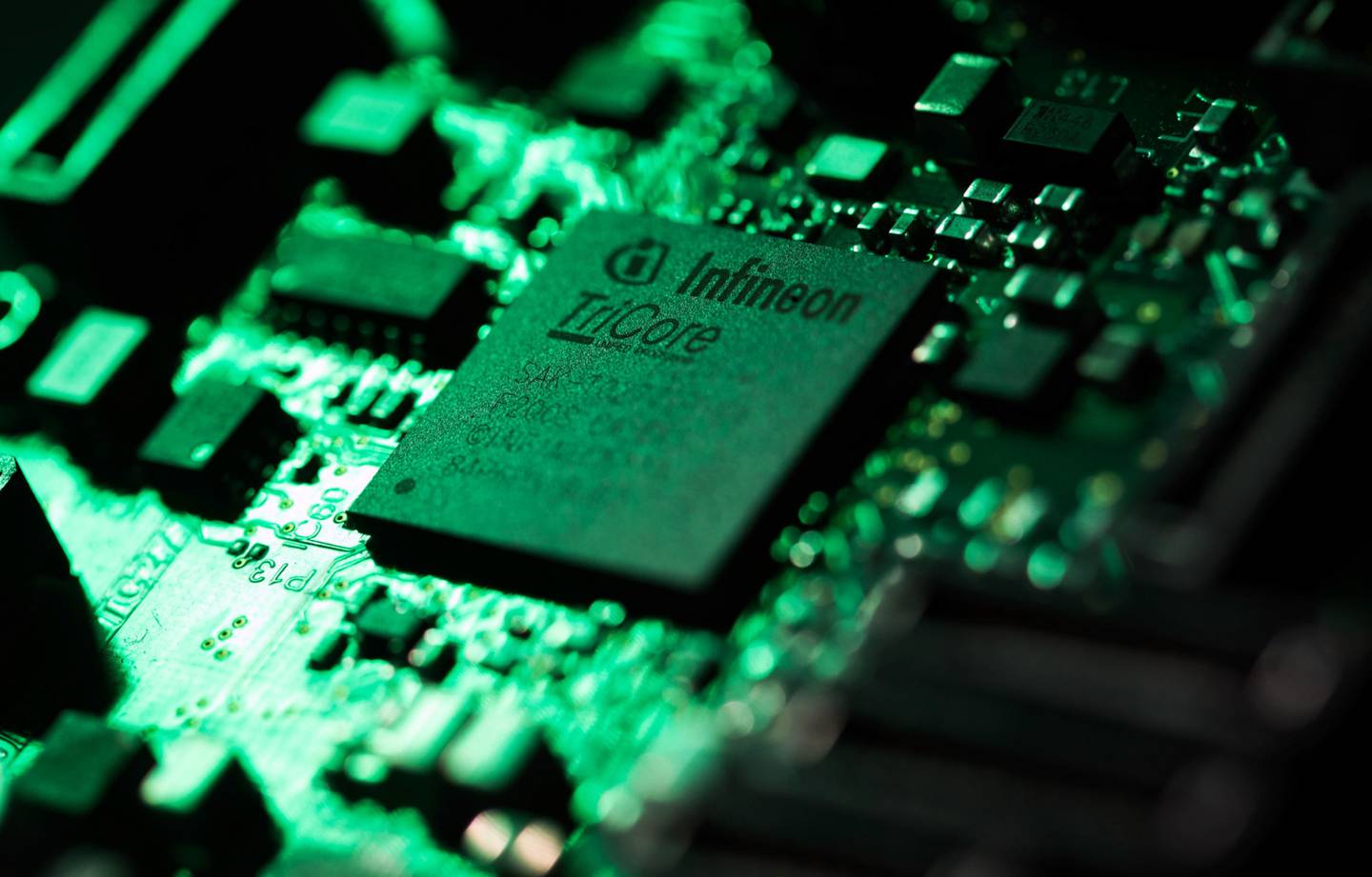 Un componente del circuito informático del microcontrolador TriCore de Infineon se encuentra junto a  circuitos eléctricos