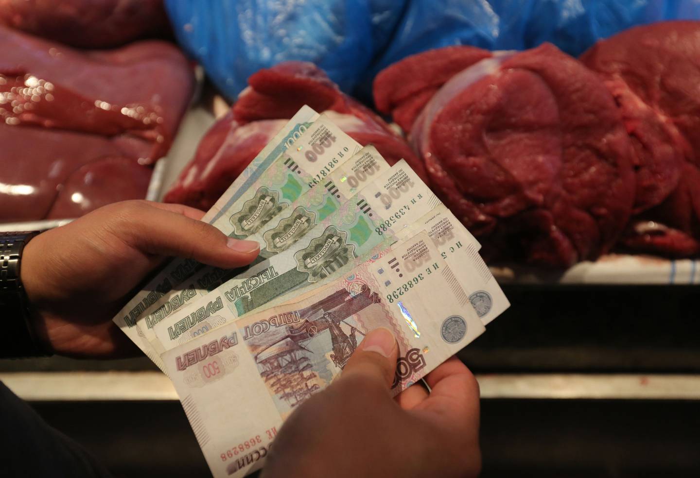 Un cliente cuenta billetes en rublos mientras compra productos cárnicos de granja a un comerciante en el mercado de alimentos Dorogomilovsky en Moscú, Rusia, el viernes 10 de agosto de 2018.dfd