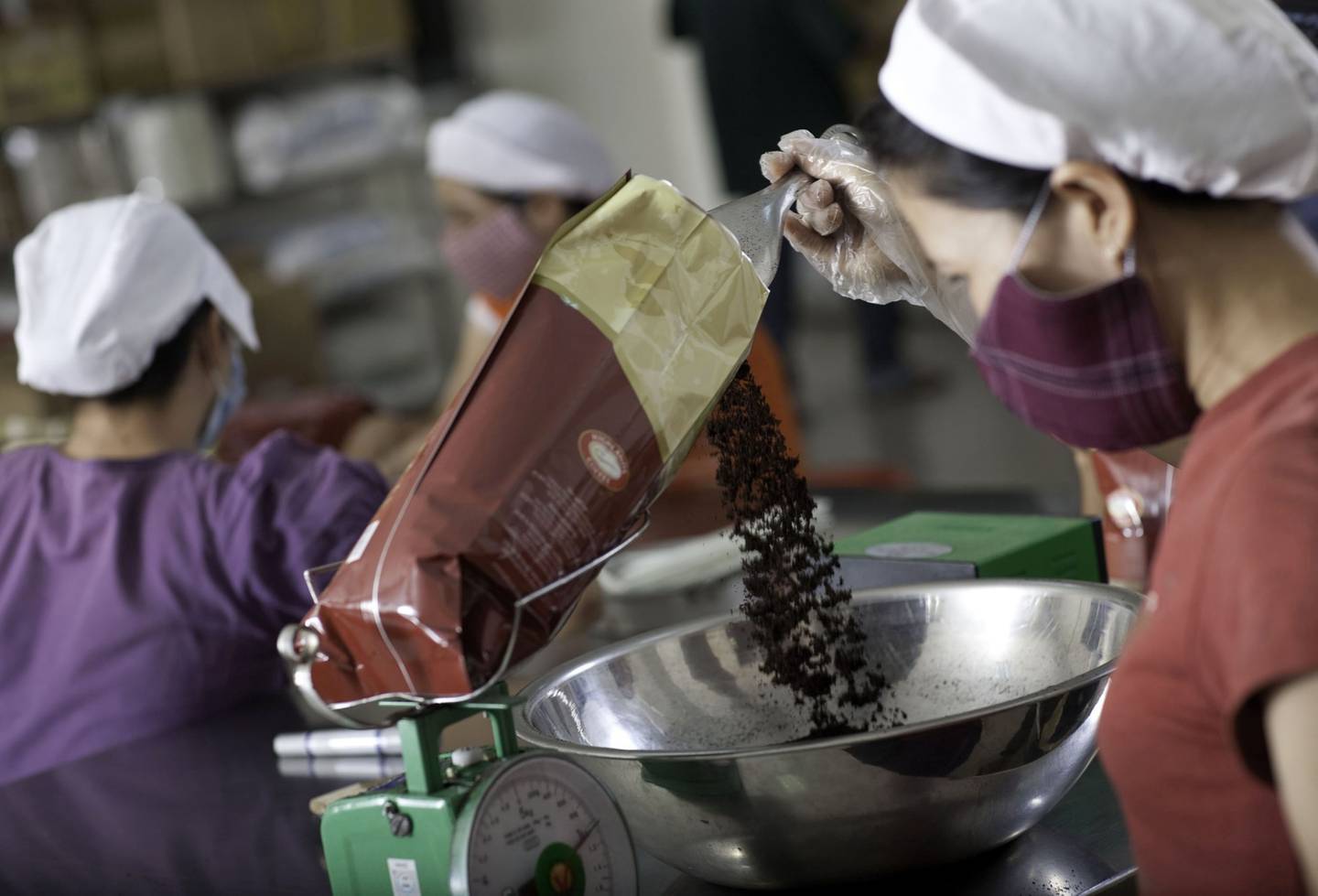 Un trabajador embolsa y pesa granos de robusta tostados y molidos para su distribución en la planta de procesamiento de café Highlands en Ciudad Ho Chi Minh, Vietnam, el viernes 1 de octubre de 2010.  Fotógrafo: Jeff Holt/Bloomberg