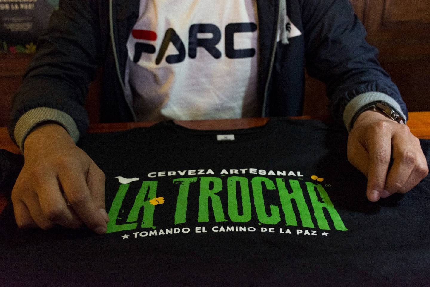 Una camiseta de la marca de cerveza La Trocha sobre una mesa de un bar en Colombia.dfd