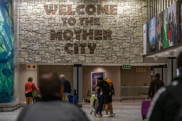 Travelers embrace inside the arrivals hall at Cape Town International Airport in Cape Town, South Africa, on Friday, Dec. 3, 2021.
