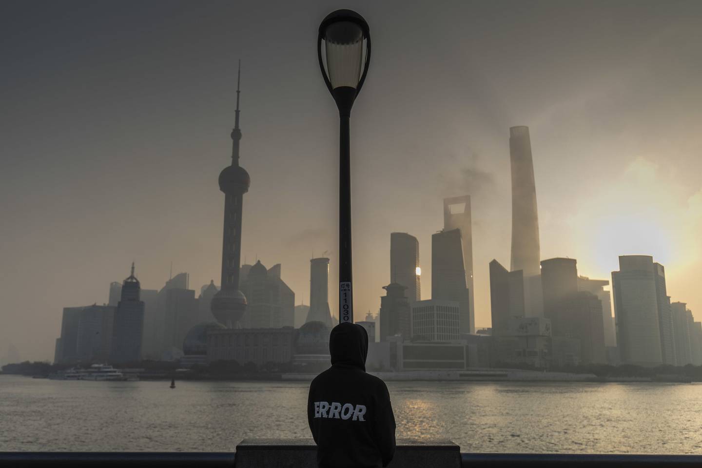 Pedestre observa o distrito financeiro de Xangai