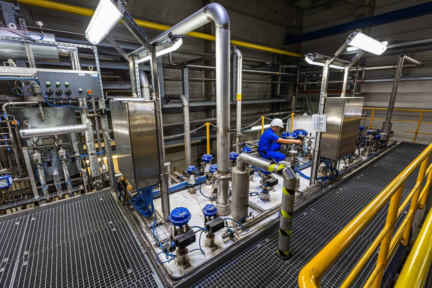 Un empleado ajusta una válvula en la caja fría para la producción de hidrógeno líquido (LH2) en una planta de hidrógeno de Linde AG en Leuna, Alemania, el martes 14 de julio de 2020.dfd