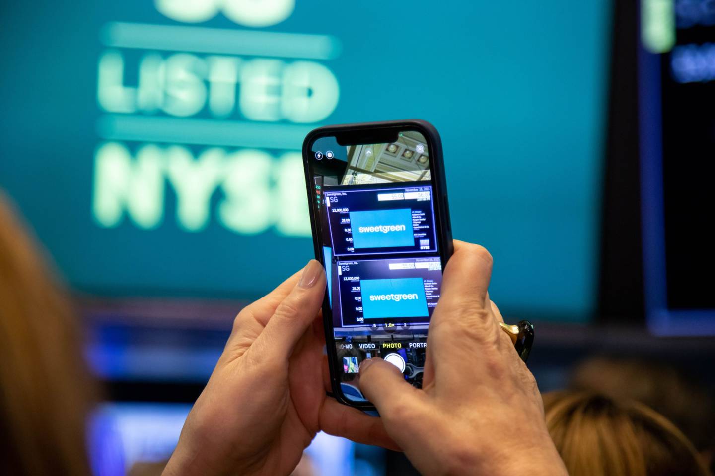 An attendee photographs signage on the floor of the New York Stock Exchange (NYSE) in New York, U.S. Photographer: Michael Nagle/Bloomberg
