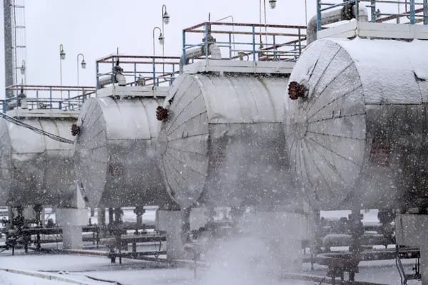 La nieve cae mientras el vapor sale de las tuberías cerca de los cilindros de gas en el sitio de procesamiento y perforación de campos de petróleo y gas operado por Ukrnafta PJSC en Gnidyntsi, región de Chernihiv, Ucrania, el martes 29 de noviembre de 2016.