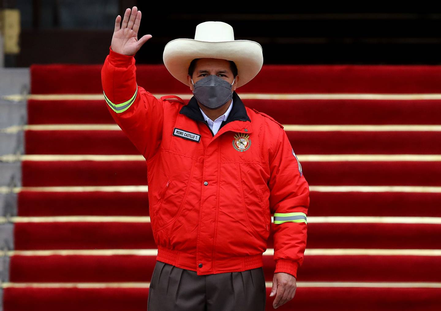LIMA, PERU - DECEMBER 05: Peruvian President Pedro Castillo (C) wears a firefighter jacket and salutes during an event to deliver firetrucks to Volunteer firefighters of Peru on December 5, 2021 in Lima, Peru. After only four months in power, National Congress will vote this week on whether to start the formal impeachment process to Castillo. The Left-wing President will also be questioned by prosecutors on December 14th over promotions for military officers. (Photo by Leonardo Fernandez/Getty Images)dfd