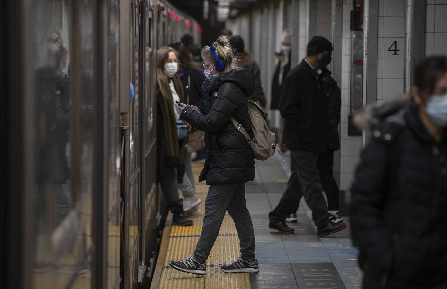 Viajeros suben y bajan de un tren subterráneo en una estación de Nueva York.