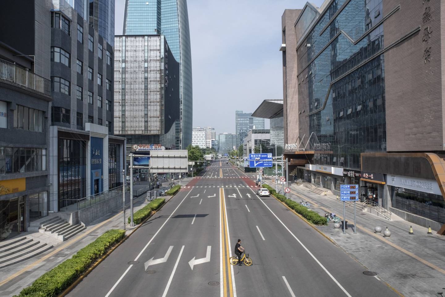 Ciclista em avenida vazia de Pequim por causa de restrições à circulação por causa da pandemia de Covid