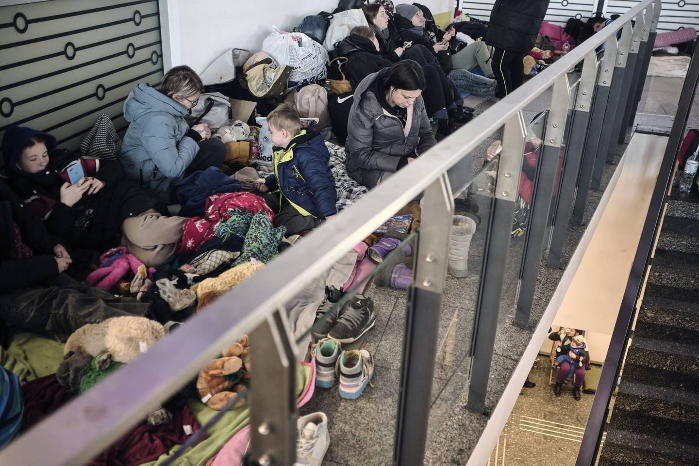 Ucranianos desplazados descansan mientras esperan en la estación central de trenes de Varsovia, Polonia, el jueves 10 de marzo de 2022.