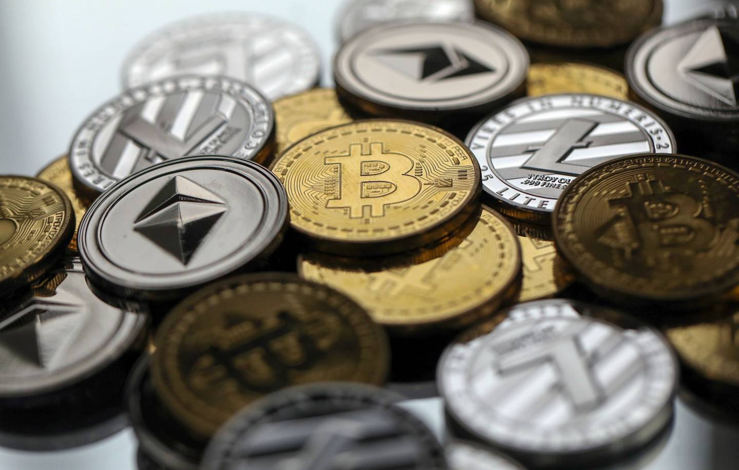 A collection of bitcoin, litecoin and ethereum tokens sit in this arranged photograph in Danbury, U.K., on Tuesday, Oct. 17, 2017. On Wednesday, billionaire Warren Buffett said on CNBC that most digital coins won't hold their value.