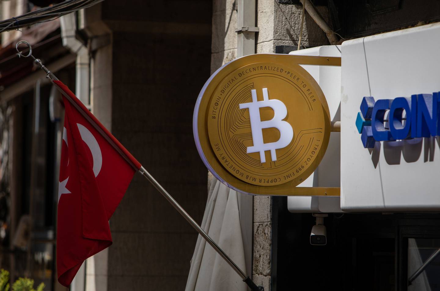 Un cartel con el logotipo de bitcoin junto a una bandera nacional turca frente a un quiosco de intercambio de criptodivisas en Estambul, Turquía, el martes 26 de abril de 2022.