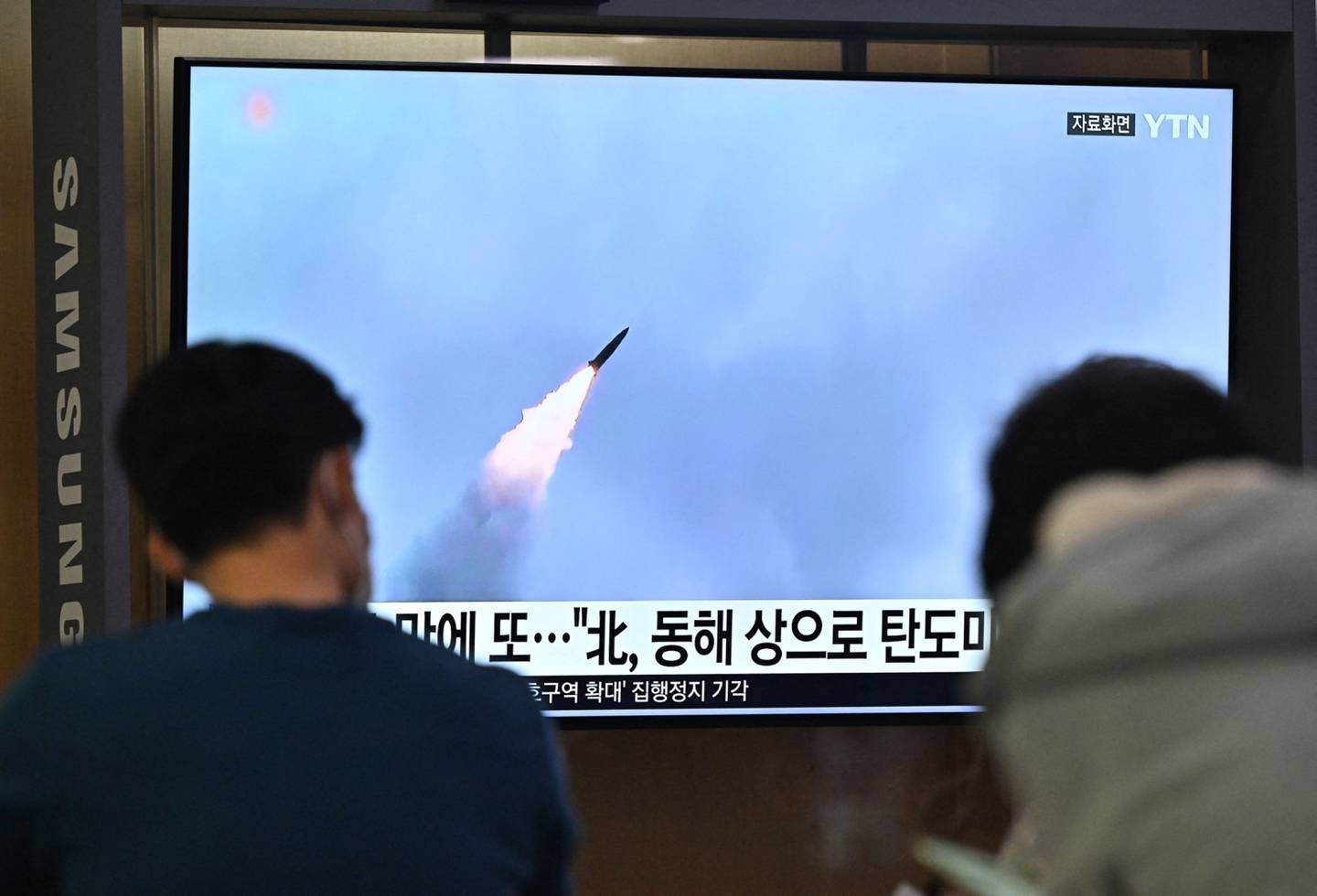 La gente mira una pantalla de televisión que muestra un noticiero con imágenes de archivo de una prueba de misiles de Corea del Norte, en una estación de tren en Seúl el 29 de septiembre de 2022. Fotógrafo: Jung Yeon-Je/AFP/Getty Images