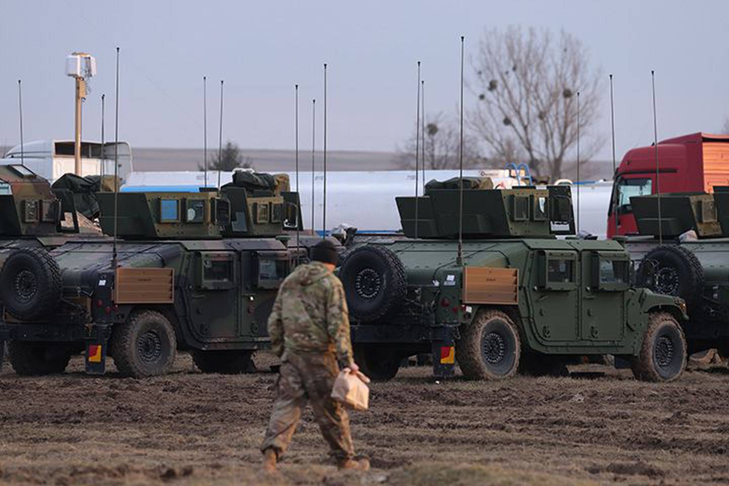 Un soldado del Ejército de EE.UU. camina hacia los vehículos militares Humvee estacionados en un aeródromo que actualmente utiliza la 82 División Aerotransportada del Ejército en Zamosc, Polonia, el 1 de marzo.