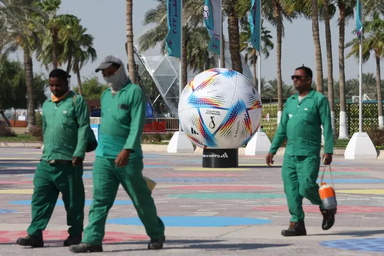 Workers pass a model of the Adidas official FIFA World Cup 2022 'Al Rihla' ball.dfd