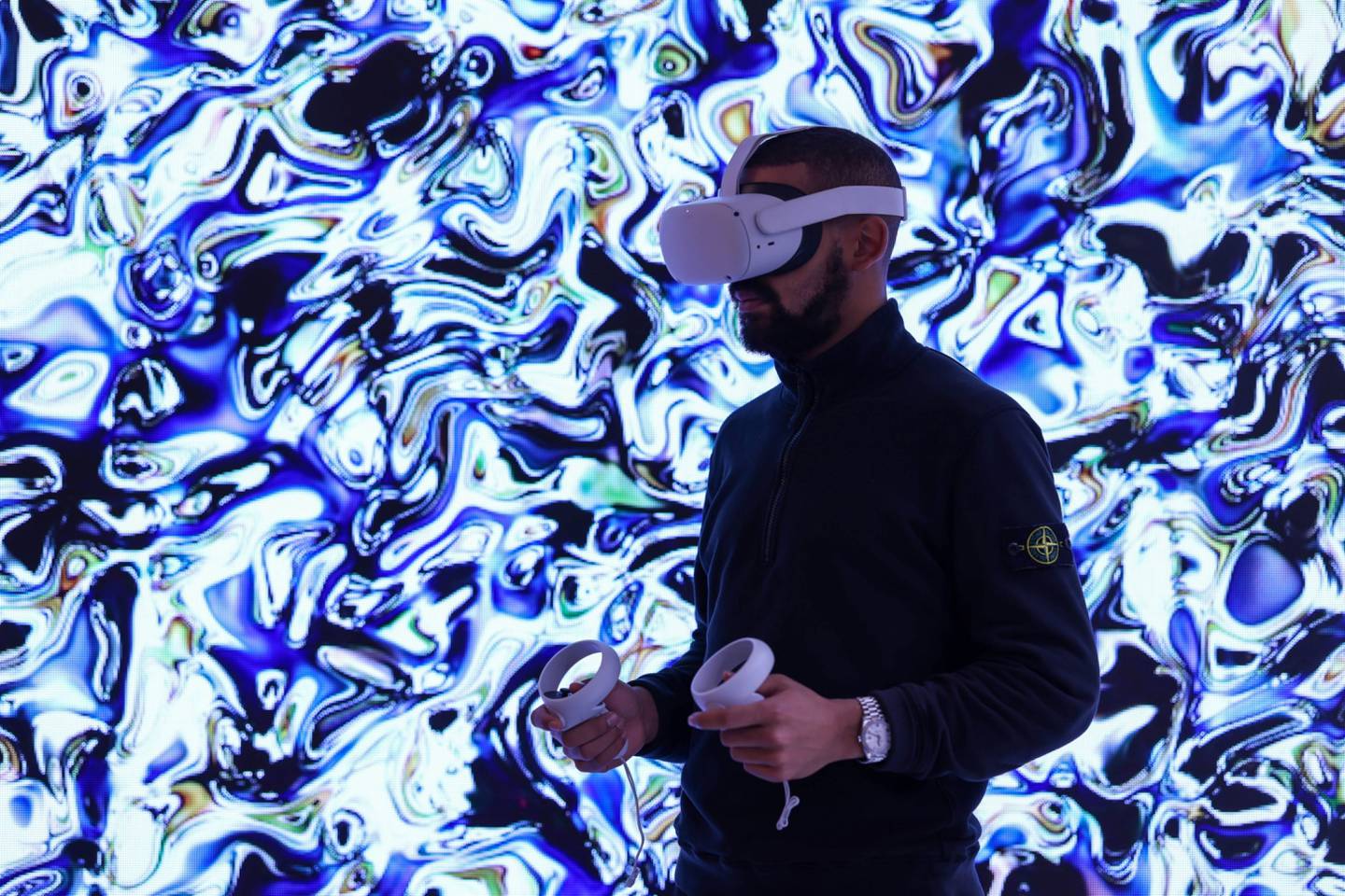Un asistente de galería que usa un casco de realidad virtual (VR) Oculus Quest 2 para ver la galería Metaverse de House of Fine Art (HOFA).