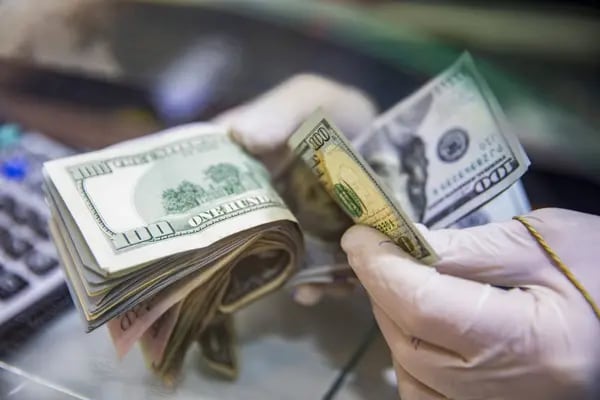 Un trabajador cuenta billetes de 100 de la divisa estadounidense.