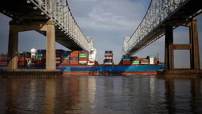 Um navio porta-contêineres passa sob a ponte Crescent City Connection perto do porto de Nova Orleans