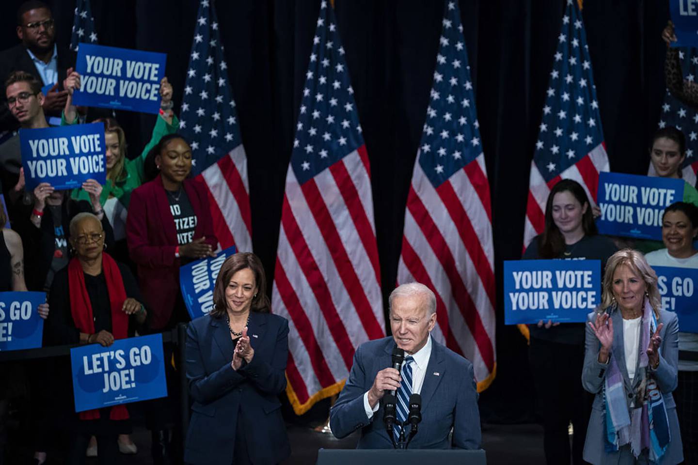 US President Joe Biden, bottom center, speaks as US Vice President Kamala Harris, center left, and First Lady Jill Biden, right, listen during a Democratic National Committee (DNC) rally.