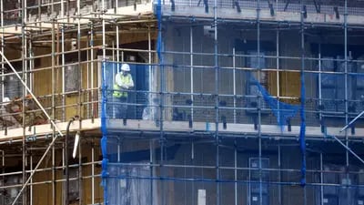 Un trabajador mira desde un andamio en un sitio de construcción el viernes 8 de octubre de 2021.