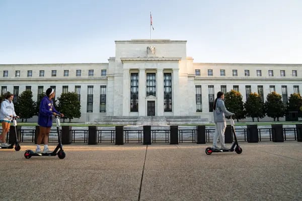 Un grupo de personas pasa en patineta por delante del edificio Marriner S. Eccles de la Reserva Federal en Washington, D.C., Estados Unidos, el martes 18 de agosto de 2020.