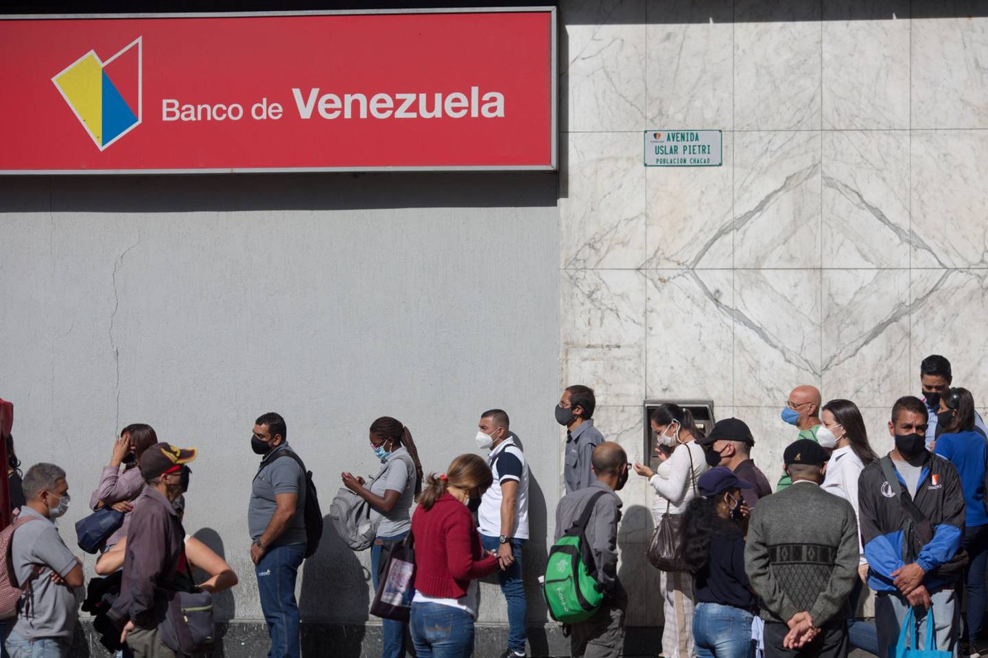 Gente espera en fila frente a una sucursal del Banco de Venezuela en Caracas, Venezuela, el lunes 15 de marzo de 2021.