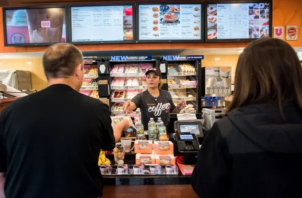 Un empleado ayuda a los clientes en una ubicación de Dunkin' Donuts Inc. en Ramsey, Nueva Jersey, EE.UU., el jueves 5 de mayo de 2016.