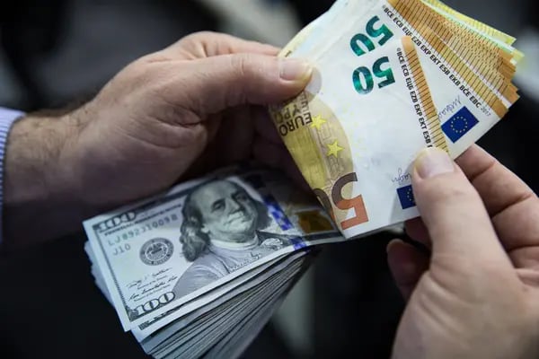 Un hombre cuenta un fajo de billetes de 50 euros y de cien dólares estadounidenses en Turquía. Fotógrafo: Kerem Uzel/Bloomberg