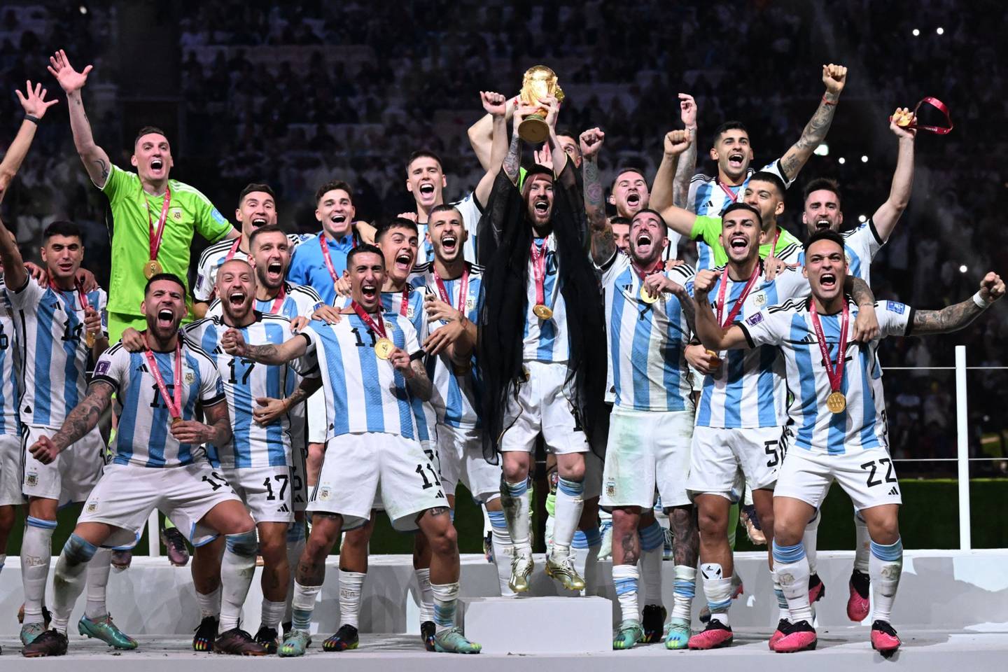 Argentina's captain and forward #10 Lionel Messi (C) lifts the FIFA World Cup Trophy as he celebrate with teammates winning the Qatar 2022 World Cup final football match between Argentina and France at Lusail Stadium in Lusail, north of Doha on December 18, 2022.  Photographer: Kirill Kudryavtsev/AFP/Getty Images