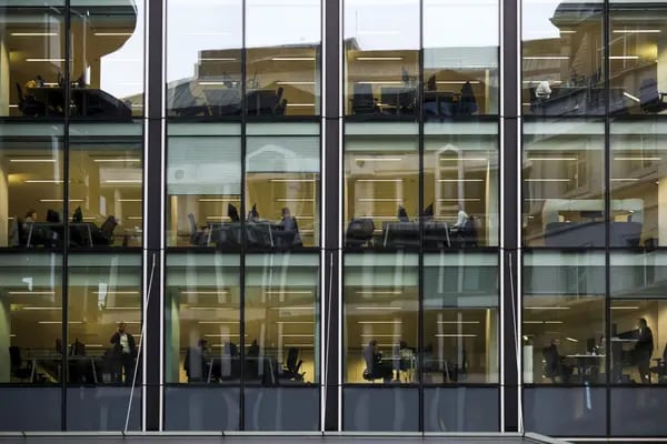 Employees work at their desks inside an office building in London.