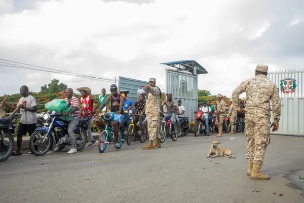 Miembros del Cuerpo Especializado de Seguridad Fronteriza dirigen a los peatones que llegan desde Haití a la República Dominicana. La República Dominicana está construyendo una barrera para aislar una de las economías más exitosas de la región del caos en Haití.