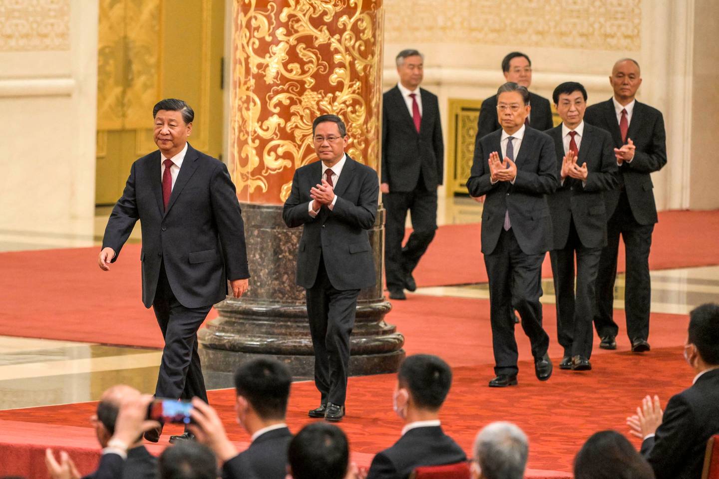 China's President Xi Jinping (L) walks with (2nd L to R) Li Qiang, Li Xi, Zhao Leji, Ding Xuexiang, Wang Huning and Cai Qi, members of the Chinese Communist Party's new Politburo Standing Committee, the nation's top decision-making body, as they meet the media in the Great Hall of the People in Beijing on October 23, 2022.  Photographer: Wang Zhao/AFP/Getty Images