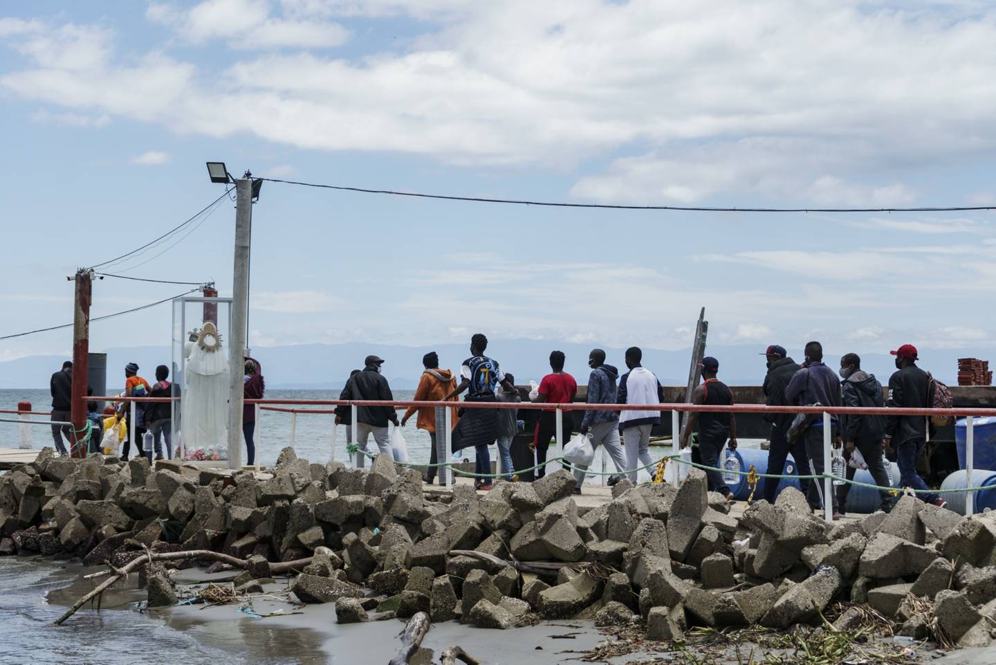 Migrantes esperan en fila para abordar un bote en un puerto en Necoclí, departamento de Antioquia, Colombia, el sábado 31 de julio de 2021.