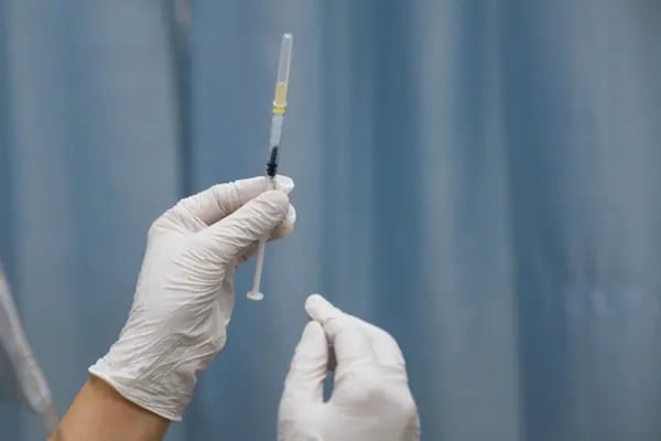 Una persona sostiene una jeringa para administrar una dosis de una vacuna contra el Covid-19.