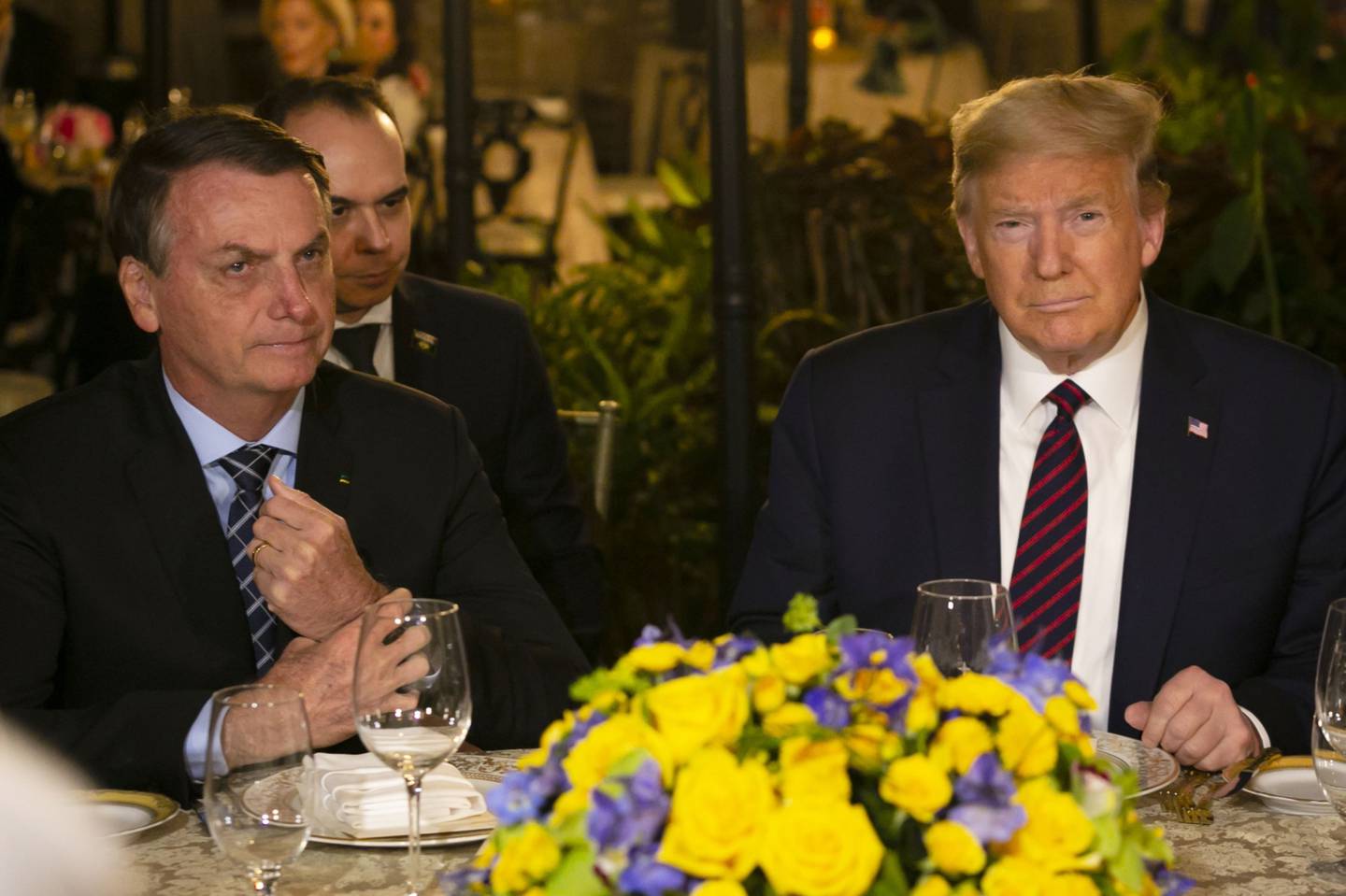Former U.S. President Donald Trump, right, and Jair Bolsonaro, Brazil's former president, sit during a dinner at Mar-a-Lago resort in Palm Beach, Florida, U.S., on Saturday, March 7, 2020.